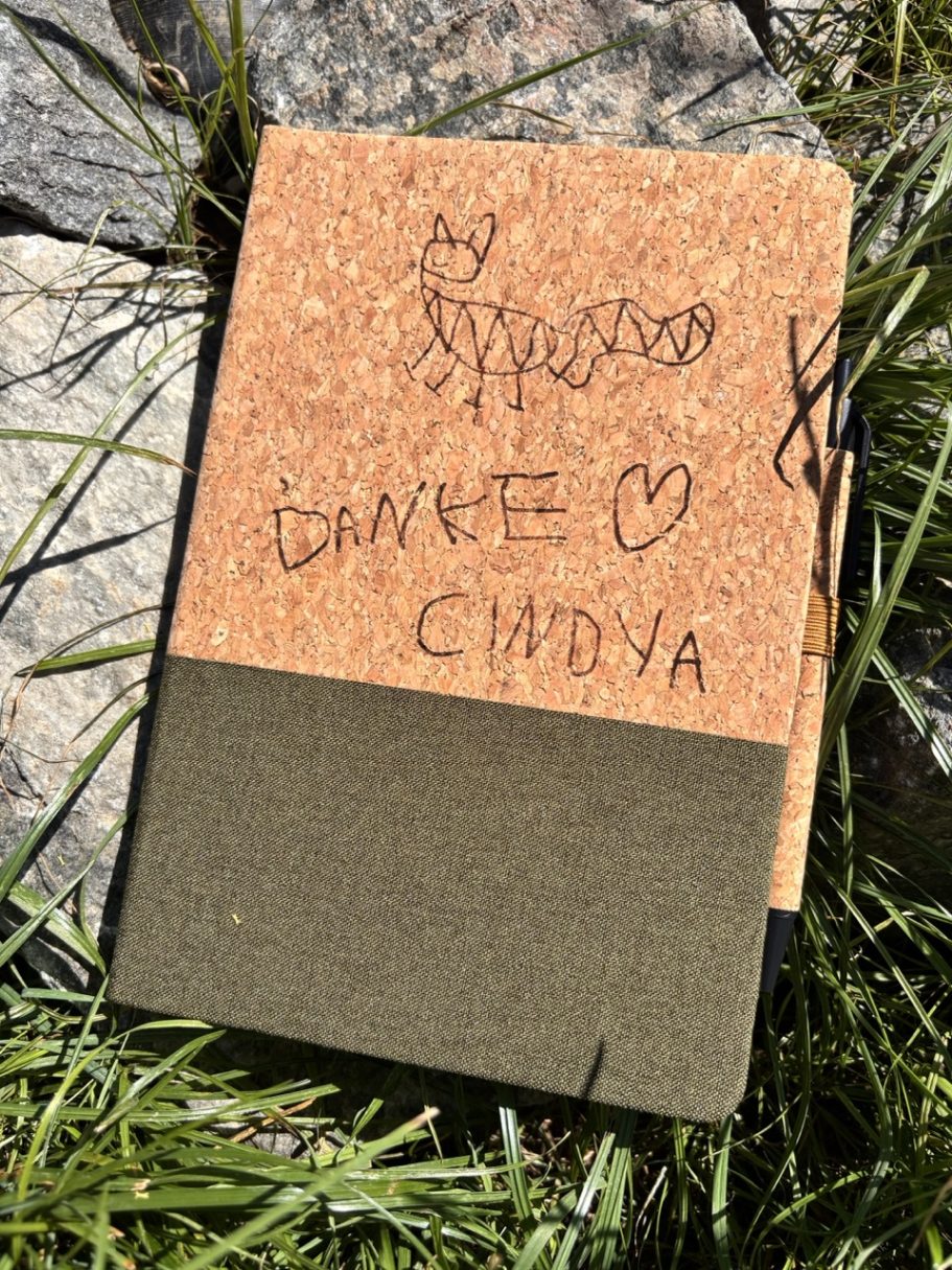 Individuell graviertes Notizbuch als Geschenk Ein Notizbuch aus Kork mit handschriftlicher Mitteilung und Herz.