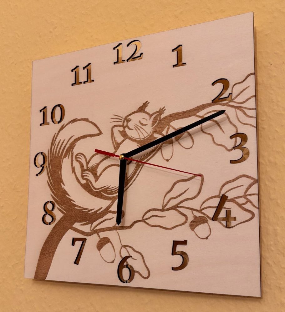 Eichhörnchen-Uhr Wanduhr mit einem grafischen Eichhörnchen und Ast, schwarze und rote Zeiger.